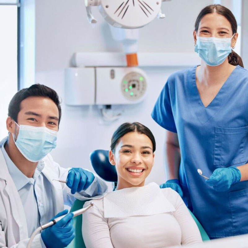 lady in dental chair smiling with dentists